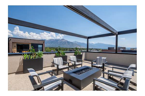 A patio with a table and chairs overlooking a mountain range.